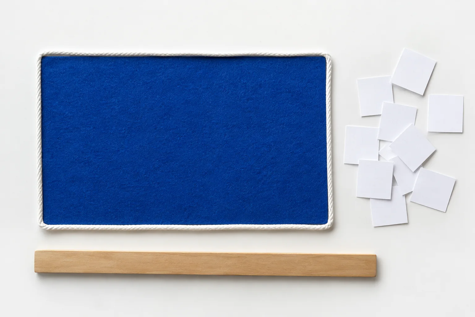 A white cord outlines blue rectangular felt while separate paper squares suggest surface coverage